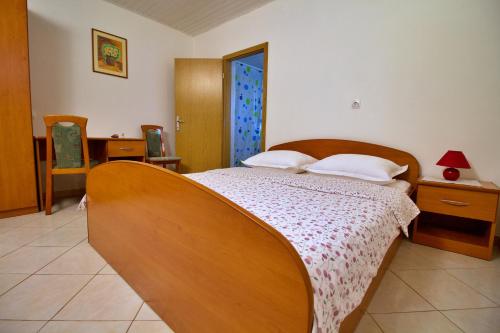 a bedroom with a large wooden bed with white pillows at Holiday house Silvana in Ždrelac