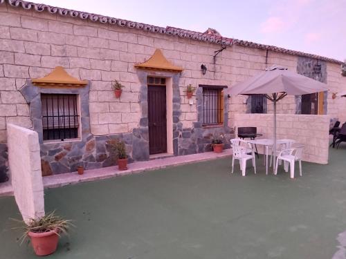 a patio with a table and an umbrella at Los Duendes in El Puerto de Santa María