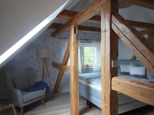 a attic room with a bunk bed and a chair at Landhaus Huchatz in Burg