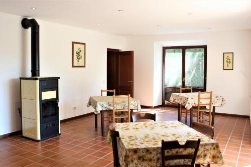 een kamer met tafels en stoelen en een fornuis bij Naturaliterre BnB - Microfattoria in Dovadola