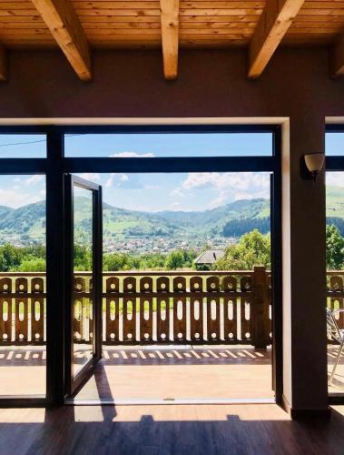 an open door to a balcony with a view at PANORAMIC Sus In Deal in Vişeu de Jos