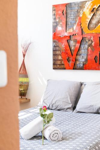 une chambre avec un lit avec un tableau sur le mur dans l'établissement LE FARNIENTE - BELLE TERRASSE Wifi Parking à 5 Min des PLAGES - TOP PROS SERVICESConciergerie La Grande Motte, à La Grande Motte