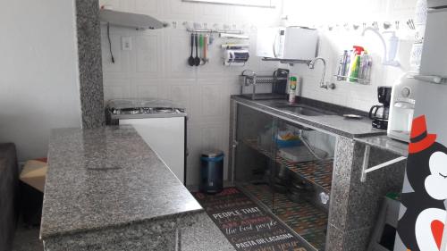 una pequeña cocina con fregadero y encimera en Chalé Brisa do Mar com Home Office, en Salinópolis