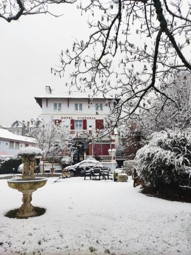 a park covered in snow with a fountain and a building at Studio vue Tourmalet dans villa historique "Victoria" in Argelès-Gazost