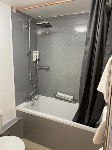 uma casa de banho com um chuveiro e uma banheira branca em The Grand Harbour hotel em Ilfracombe