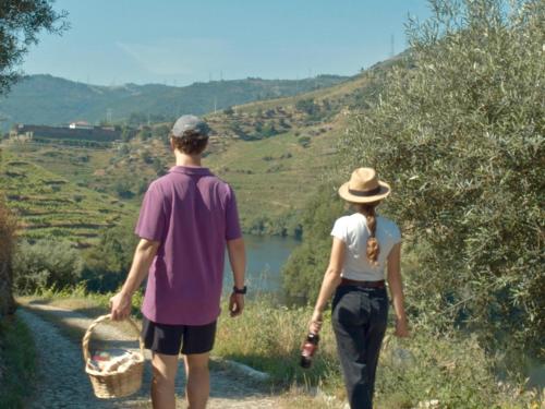 a man and a woman walking down a path with a basket at Quinta do Tedo in Folgosa
