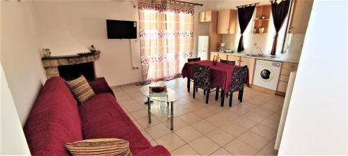 - un salon avec un canapé rouge et une table dans l'établissement Fani's apartments 3, à Ancient Epidavros