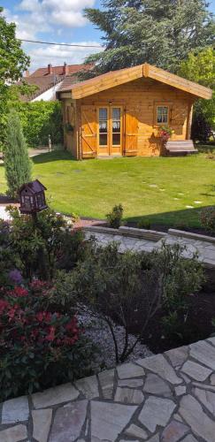 a small log cabin with a stone walkway in front at gite Labarcarole in Lillers