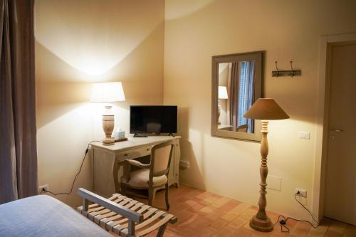 1 dormitorio con escritorio, ordenador y lámpara en Parco di Montebello, en Quattro Castella