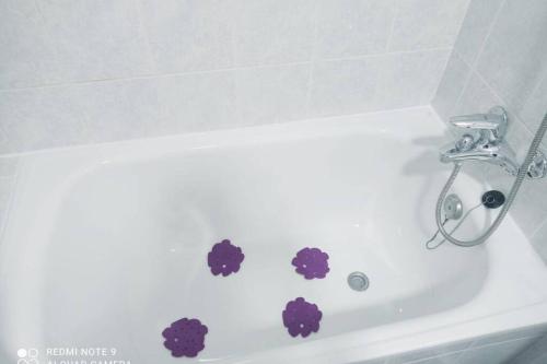 a white bath tub with purple flowers on it at Ático moderno y tranquilo con todo el confort. in Morro del Jable