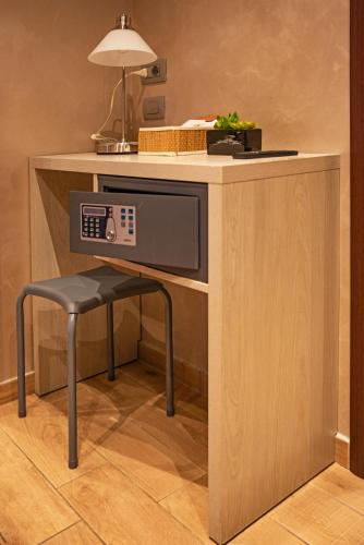 a microwave sitting on a desk with a stool underneath it at Nanà in Sanremo