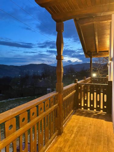 a deck with a view of the mountains at night at PANORAMIC Sus In Deal in Vişeu de Jos