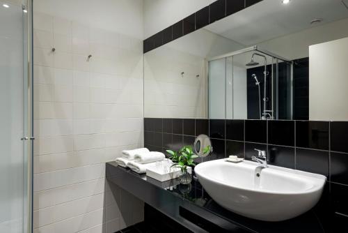 uma casa de banho com um lavatório e um espelho em B The Guest Downtown no Porto