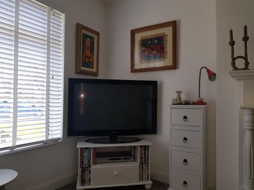 a flat screen tv sitting on a stand in a living room at Comfy House in Portstewart