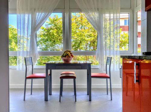 una mesa de comedor con 2 sillas y un tazón de plátanos en Apartamentos Las Calas, en Santander