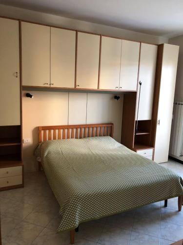 Bett in einem Zimmer mit weißen Schränken und einem Bett von 6 x 6 cm in der Unterkunft '' LA CASA DI CICI'' in Lavagna