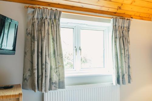 a window with curtains in a room at Yellowham Farm, Dorchester in Yellowham Wood