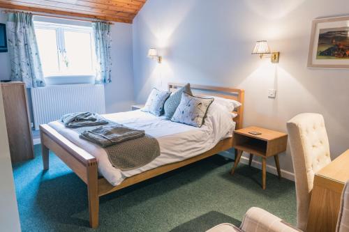 ein kleines Schlafzimmer mit einem Bett und einem Tisch in der Unterkunft Yellowham Farm in Yellowham Wood