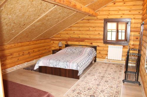 a bedroom with a bed in a log cabin at Guest House Lyubyatovo in Pskov