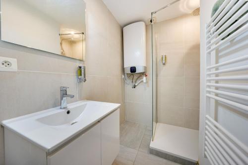 une salle de bain avec un lavabo et une douche dans l'établissement Central Avignon Netflix Nespresso Wifi Appart Hôtel Avignon, à Avignon