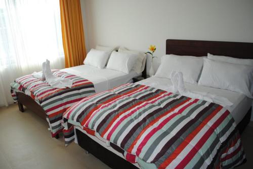 two beds sitting next to each other in a bedroom at Apartamento Quinta Avenida in Melgar