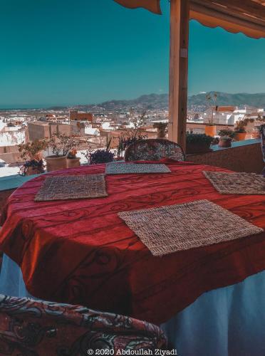 a bedroom with a red bed with a view of a city at Casa Medina Sanaa in Tetouan