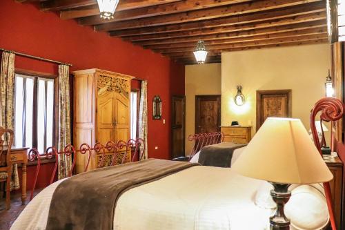 1 dormitorio con 2 camas y paredes de color rojo en Mirador del Frayle en San Miguel de Allende