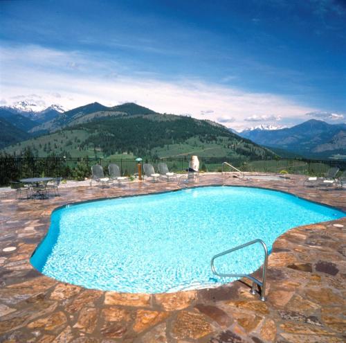 a large swimming pool with mountains in the background at Sun Mountain Lodge in Winthrop