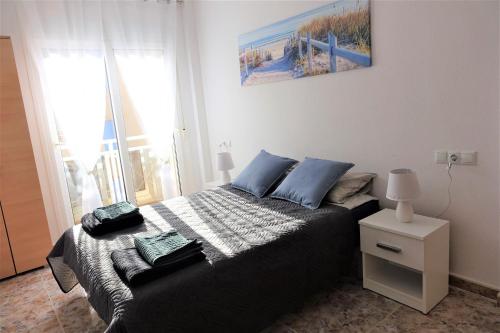 Un dormitorio con una cama con almohadas azules. en Apt SeasideJoy - Cabo Roig, Alicante, Costa Blanca, en Orihuela Costa