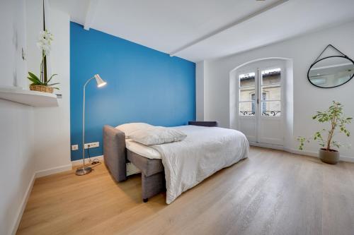 une chambre avec un lit et un mur bleu dans l'établissement Central Avignon Netflix Nespresso Wifi Appart Hôtel Avignon, à Avignon