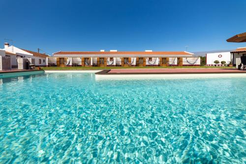 a large swimming pool in front of a building at Monte do Zeca in Zambujeira do Mar