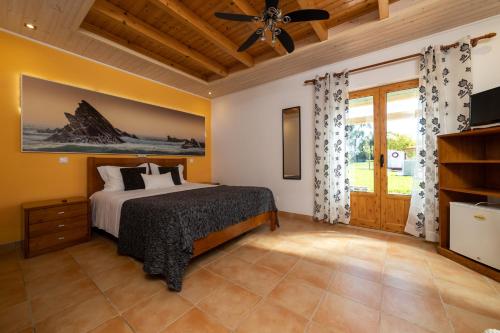 a bedroom with a bed and a ceiling fan at Monte do Zeca in Zambujeira do Mar