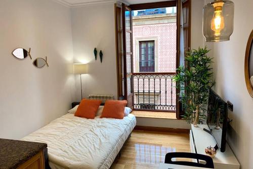 uma sala de estar com uma cama e uma janela em LUJOSA en la plaza mayor de GIJON em Gijón