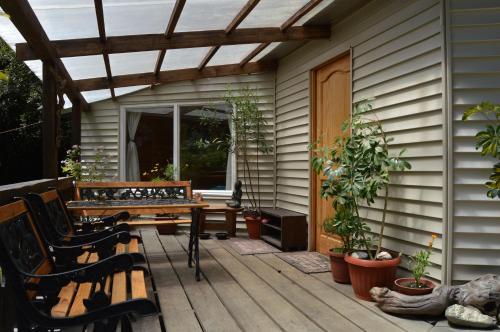 a patio with a wooden table and bench on a house at La Frontera Bed & Breakfast, Valle Cochamó in Cochamó