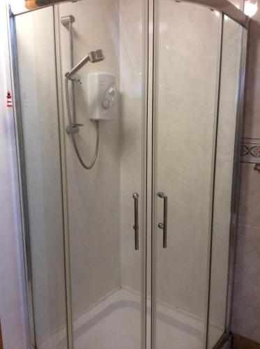 a shower with a glass door in a bathroom at Comfy House in Portstewart