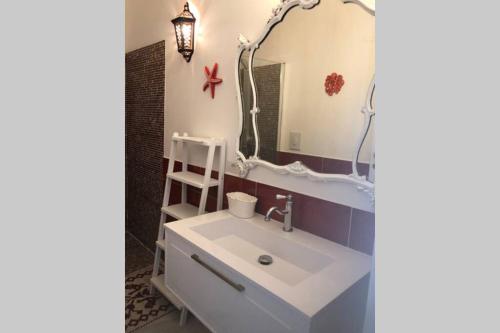 a bathroom with a sink and a mirror at Luxury & Charme fronte mare Sardinia House 5 in Carloforte