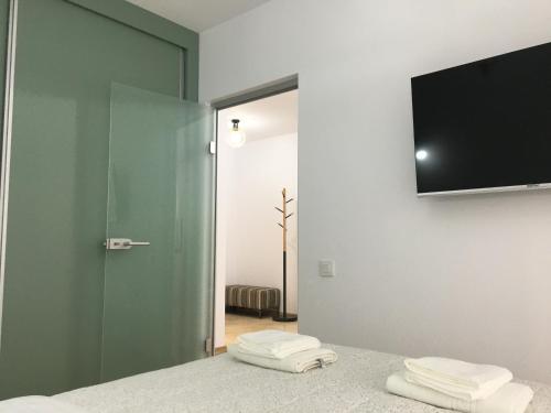 a room with a television and two towels on a bed at Top Level Residence in Oradea