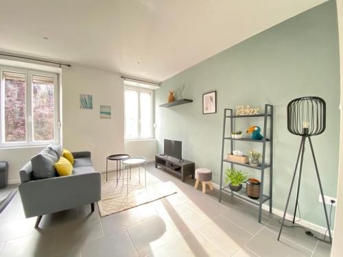een woonkamer met een bank en een tafel bij Très beau T2 42m2 lumineux, moderne et rénové avec Fibre in Belfort