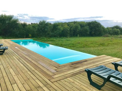 a swimming pool on a wooden deck with two chairs at Desertas Beach and Sport in Costa Nova