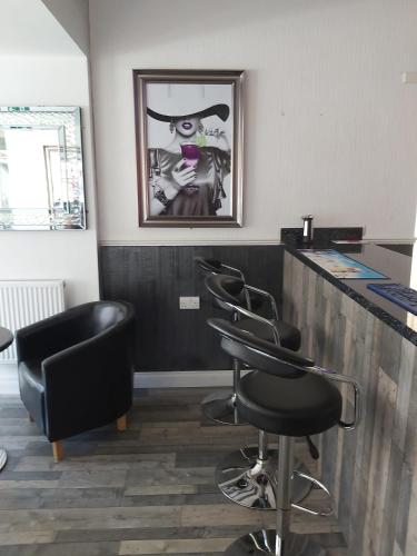 a barber shop with four barber chairs and a counter at The Dudley Hotel in Blackpool