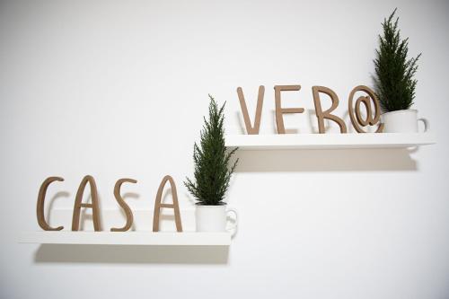 a white shelf with a vegan sign and two plants at Casa Vera in Roquetas