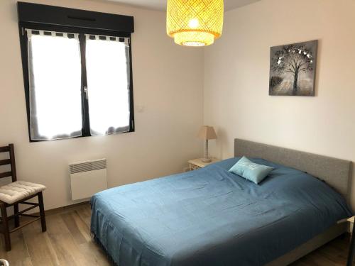 une chambre avec un lit bleu et deux fenêtres dans l'établissement Maison proximité Golf et plage de Bréville sur Mer, à Bréville-sur-Mer