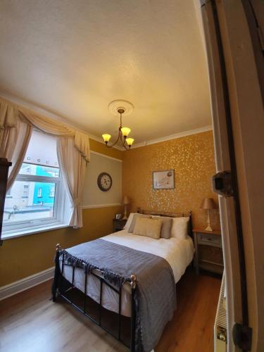 ブラックプールにあるJ's Mayfair Guest Houseのベッドルーム1室(ベッド1台、大きな窓付)