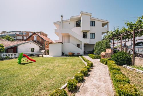 un patio con parque infantil y una casa en Apartments Radosevic, en Ulcinj