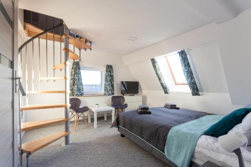 a bedroom with a bed and a spiral staircase at VILLA TO-TU in Szklarska Poręba