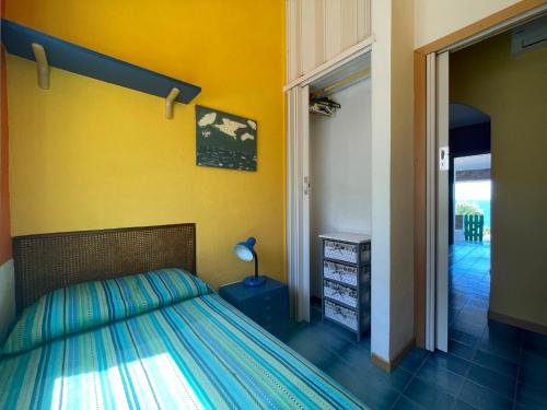 a bedroom with a bed and a yellow wall at Villa Venere al Sauce - esclusiva villa sul mare in San Vito lo Capo
