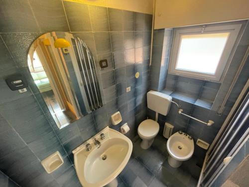 a bathroom with a sink and a toilet and a mirror at Villa Venere al Sauce - esclusiva villa sul mare in San Vito lo Capo