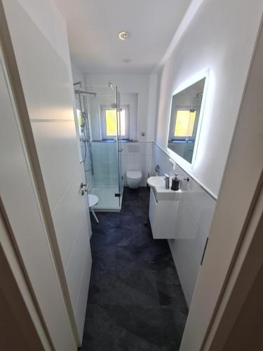 uma casa de banho com um lavatório, um WC e um espelho. em Highfield 2 rooms Apartment em Augsburg