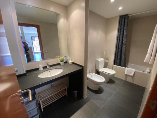W łazience znajduje się umywalka, toaleta i lustro. w obiekcie Residencial Sol i Ski 24 4p Ransol El Tarter Zona Grandvalira w mieście Sant Pere