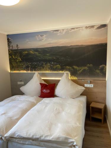 a bedroom with a bed with a painting on the wall at Paganetti´s Chalet in Breitscheid